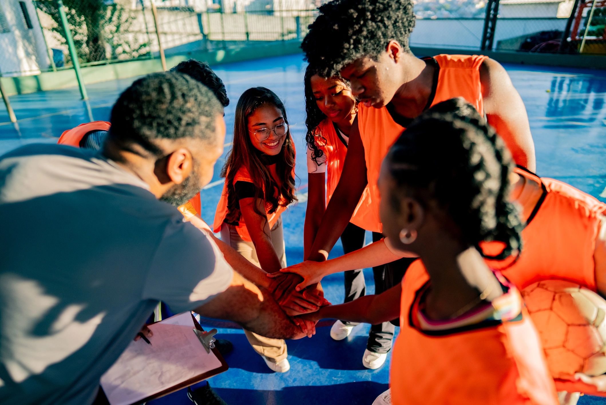 Youth athletes and coach in a team huddle